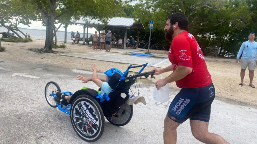 a man pushing a child in a wheelchair