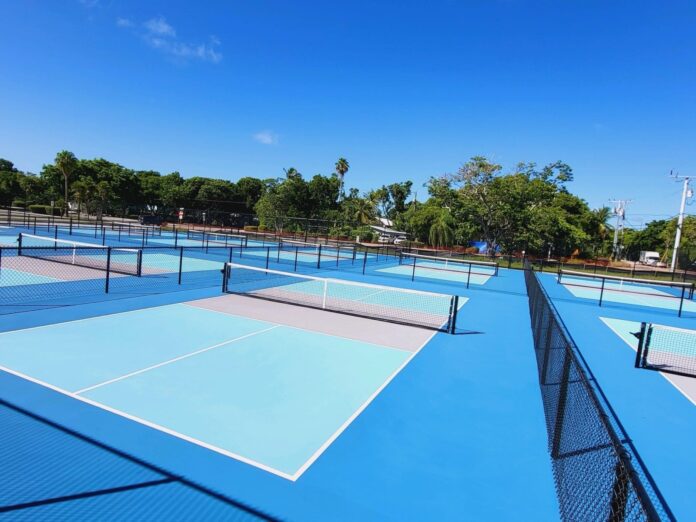 a tennis court with several tennis courts surrounded by trees