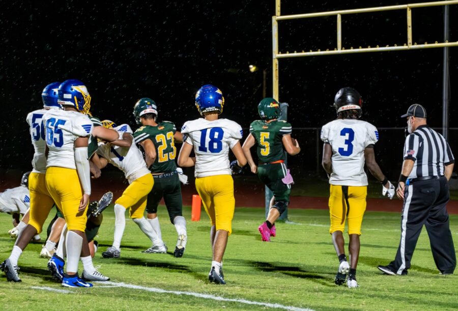 a group of football players standing on top of a field