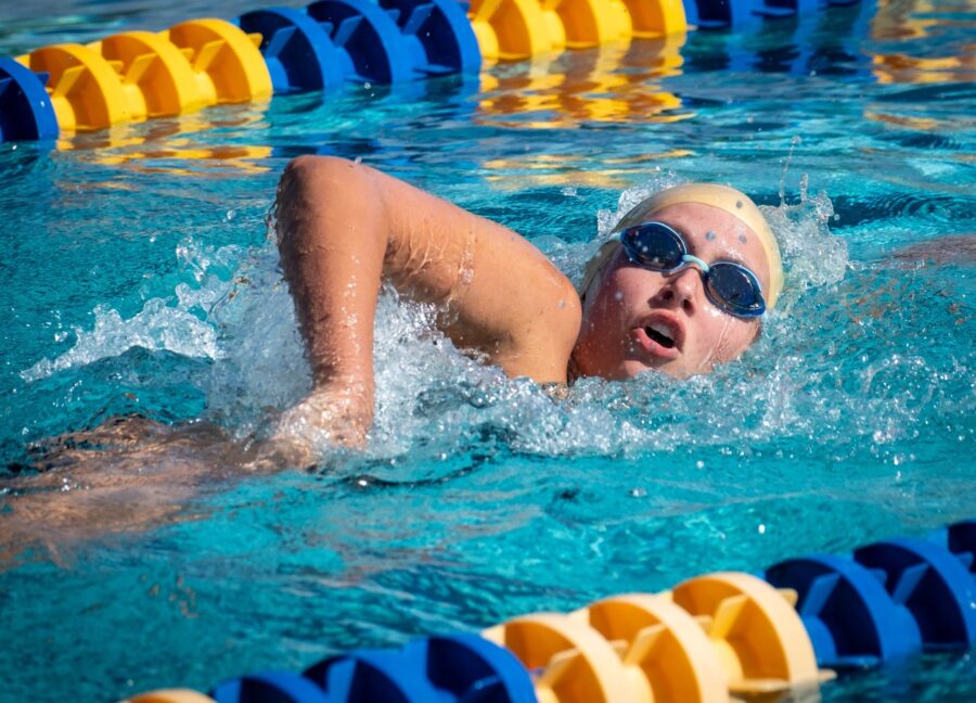 a girl swimming in a pool with goggles on