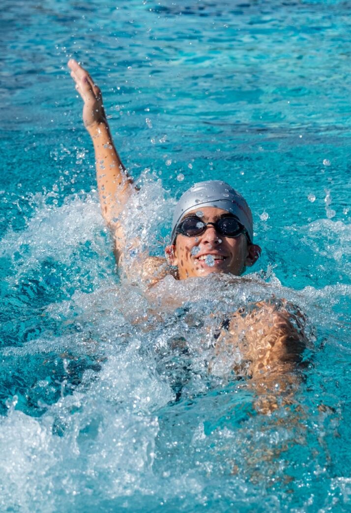 a man swimming in a pool wearing a swimming cap