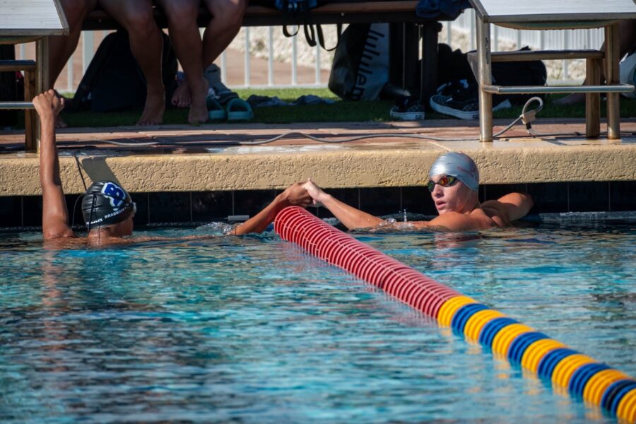 a man swimming in a pool with a swimming cap on