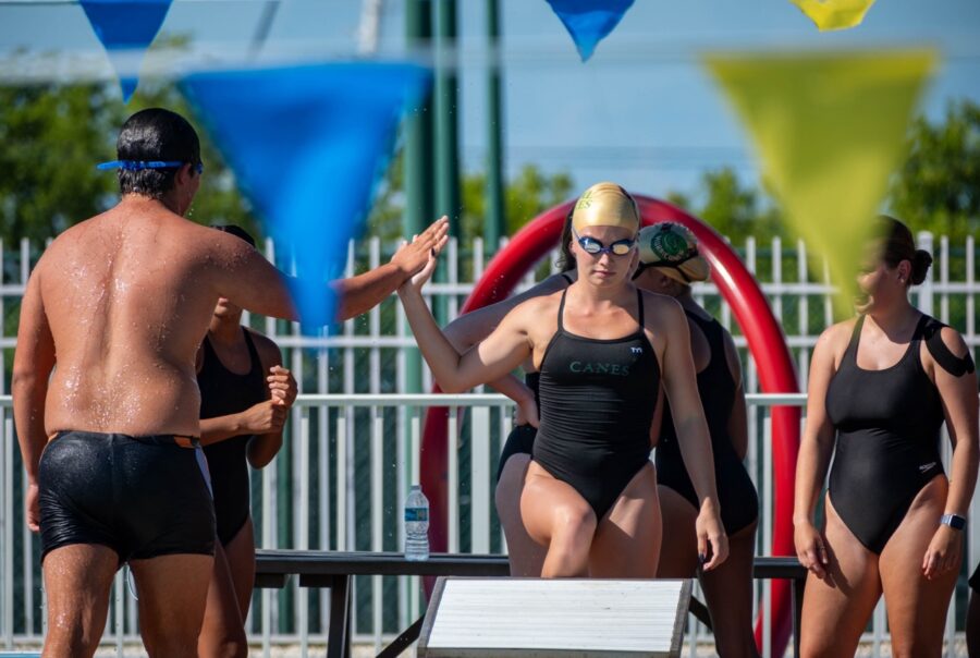 a group of people standing around a swimming pool