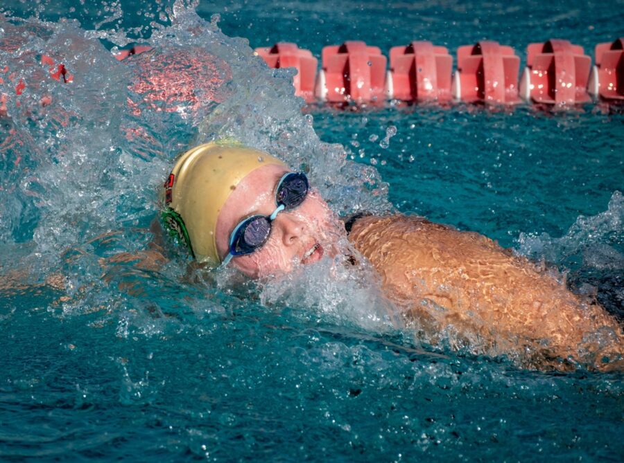 a person swimming in a pool with a helmet on