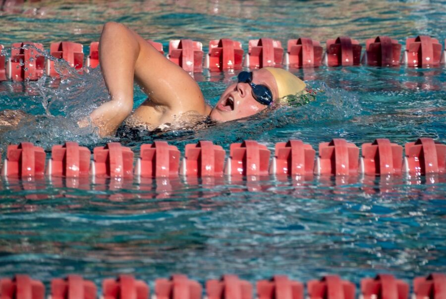 a woman swimming in a pool next to a swimming board