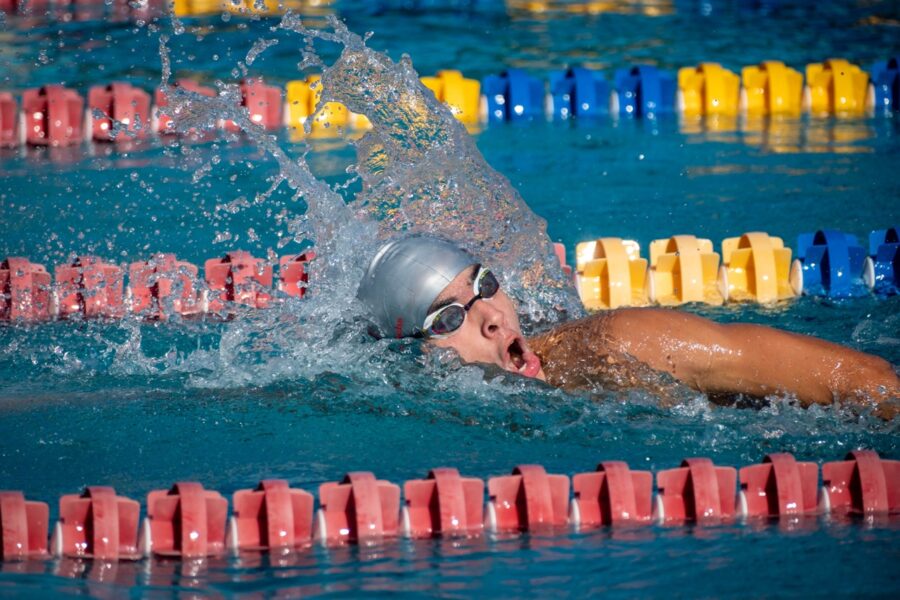 a man swimming in a pool with a helmet on