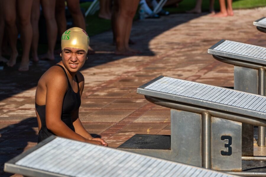 a woman in a bathing suit sitting next to a row of benches