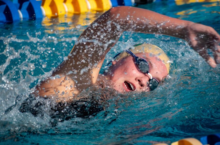 a man swimming in a pool with goggles on