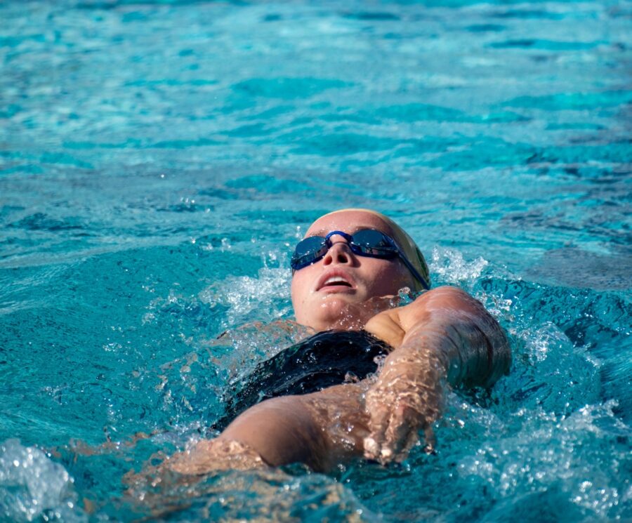 a woman swimming in a pool with goggles on