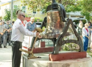 a man standing next to a large bell