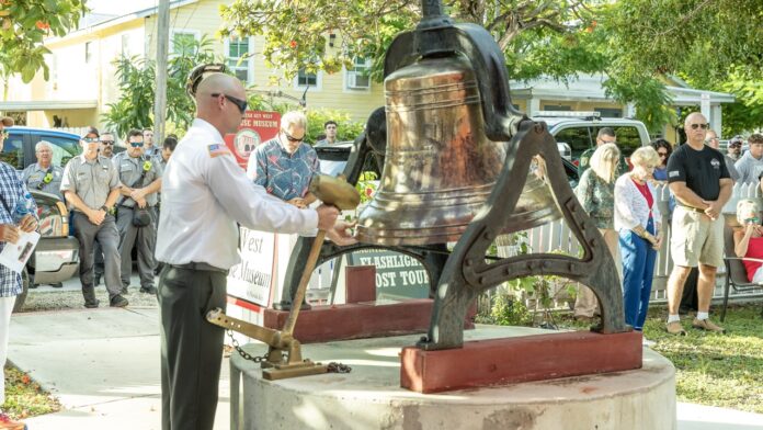 a man standing next to a large bell