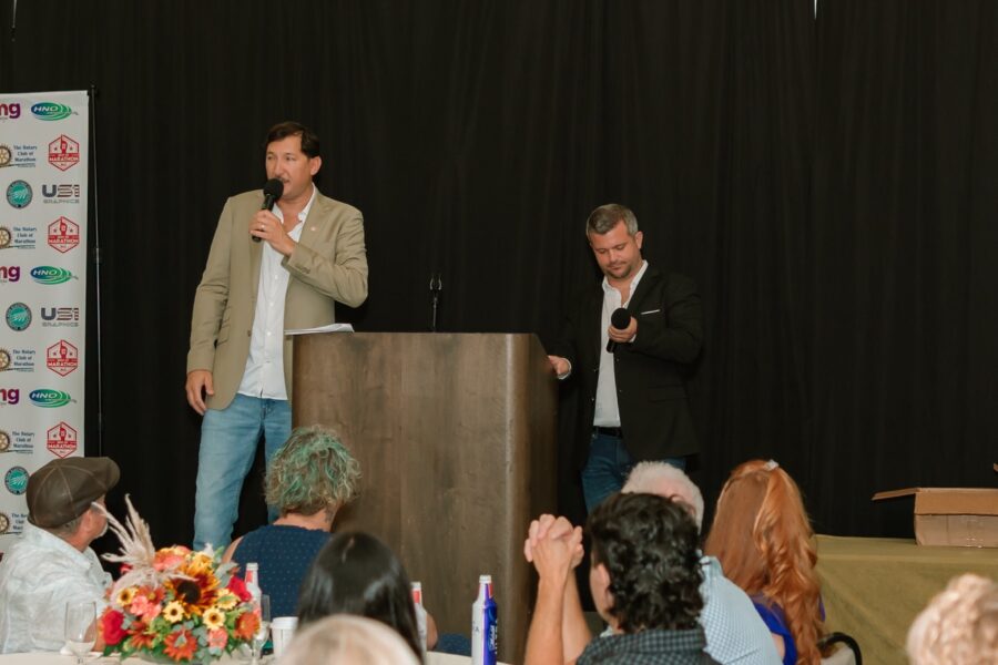 two men standing at a podium with microphones in front of them