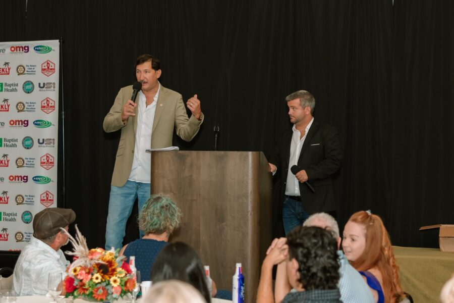 a man giving a speech to a group of people