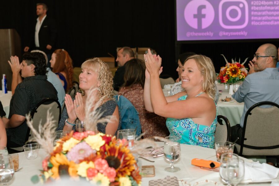 a group of people sitting at a table clapping