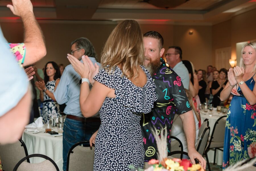 a group of people standing around a table with a cake on it