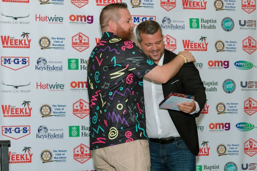 two men hugging each other on a red carpet