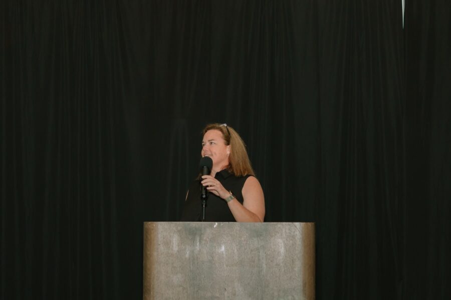 a woman standing at a podium with a microphone