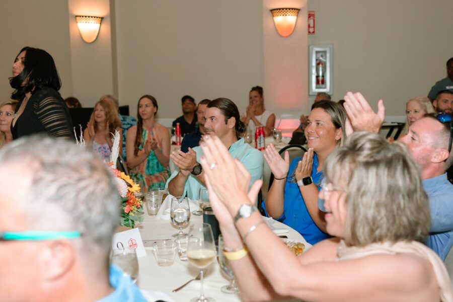 a group of people sitting around a table clapping