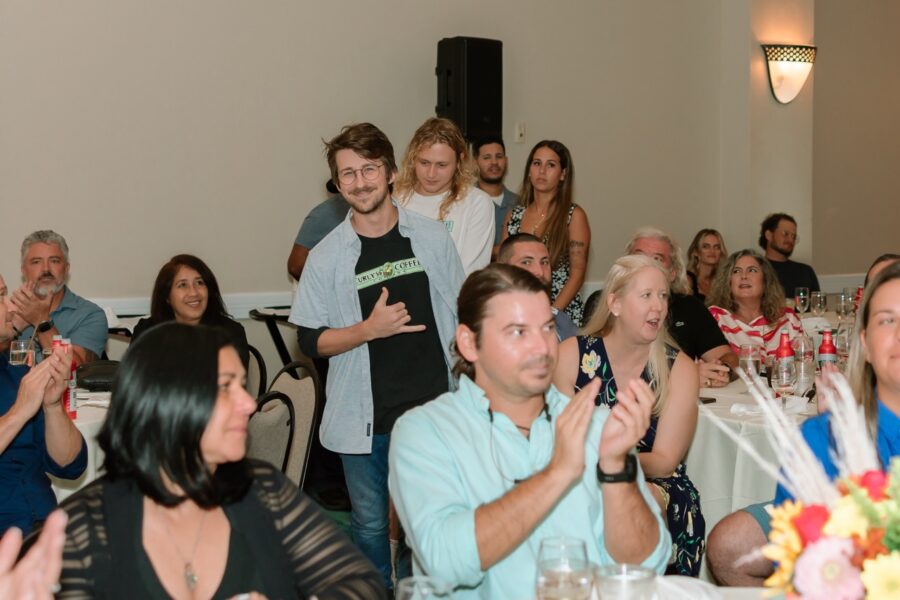 a group of people sitting at a table clapping