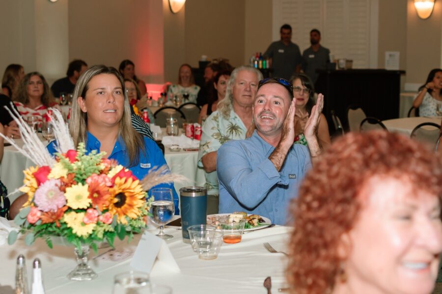 a group of people sitting at a table clapping