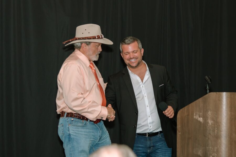 two men standing next to each other in front of a podium