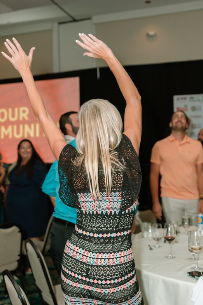 a woman in a short dress raises her arms in the air