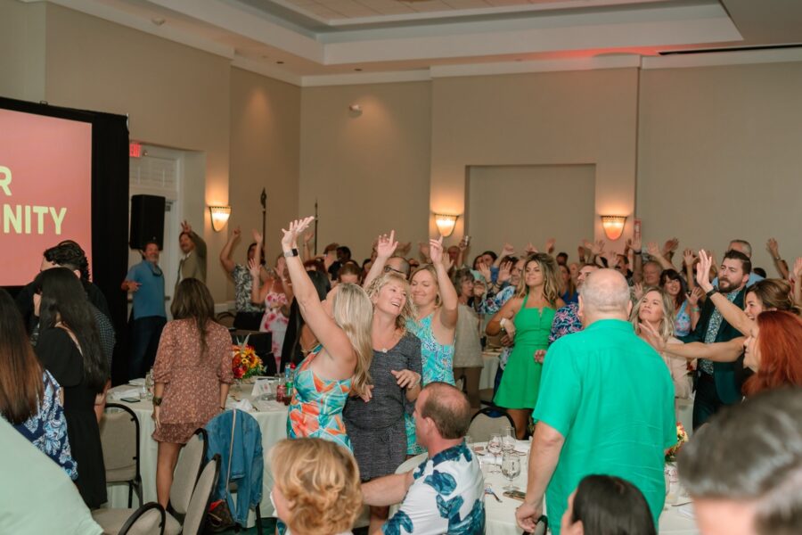 a large group of people dancing in a room