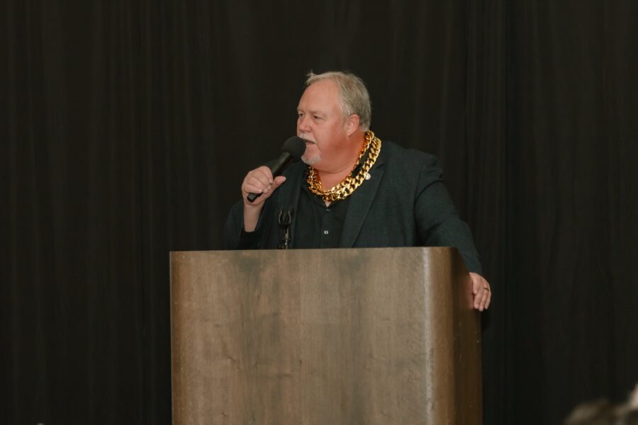 a man standing at a podium with a microphone