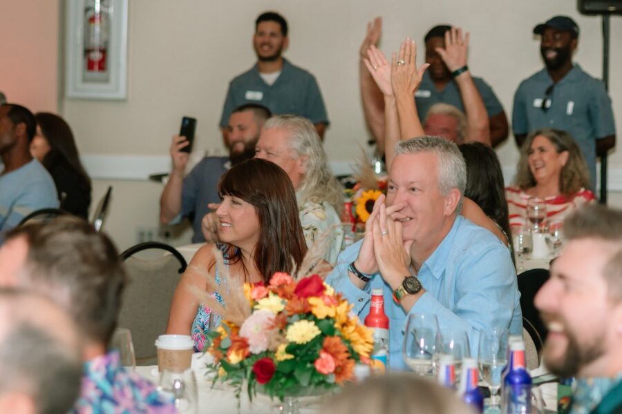 a group of people sitting at a table clapping