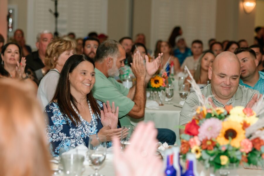 a group of people sitting at a table clapping