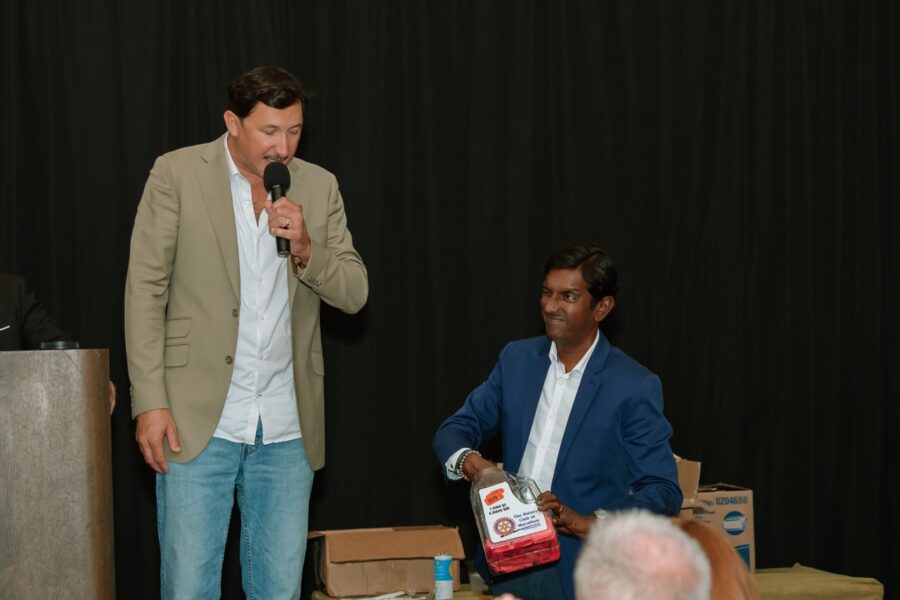 a man speaking into a microphone in front of a group of people