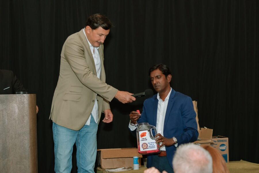 a man handing a bottle of water to another man