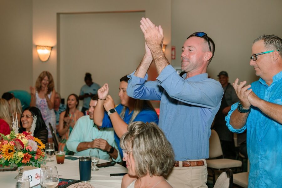 a group of people sitting around a table clapping