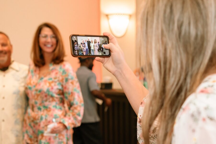 a woman taking a picture of a group of people