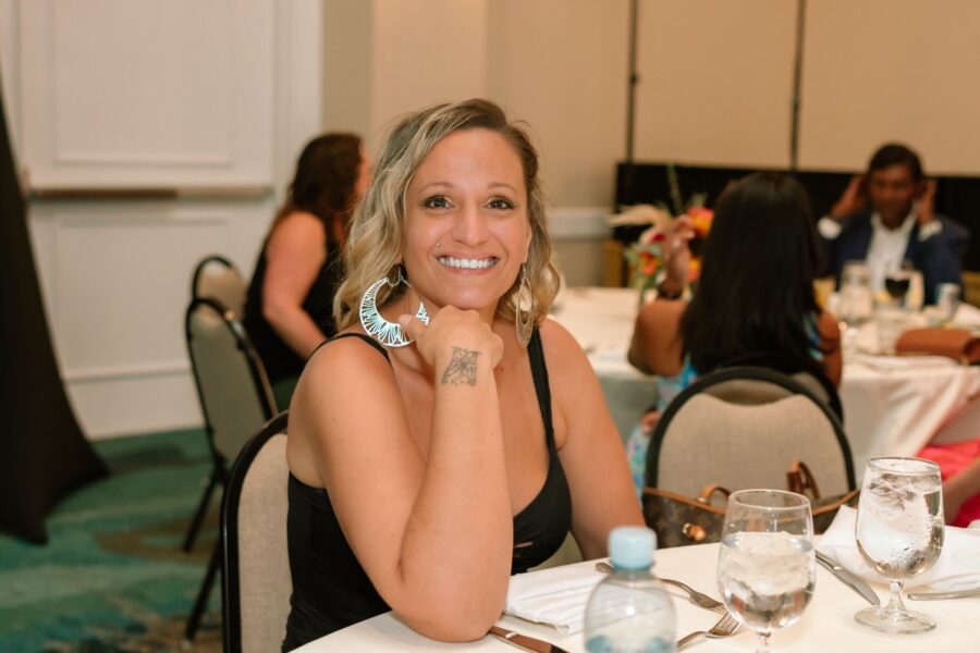 a woman sitting at a table smiling for the camera