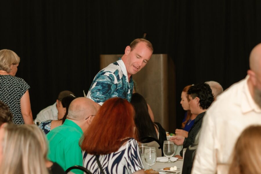 a man standing on top of a table surrounded by people