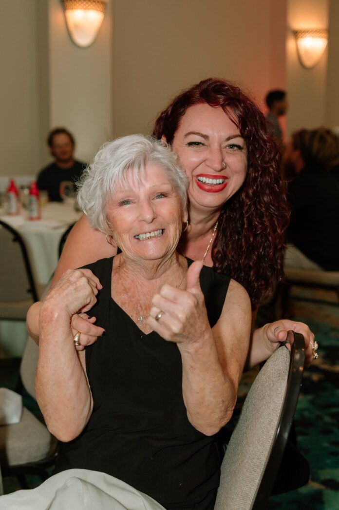 two women sitting at a table giving the thumbs up