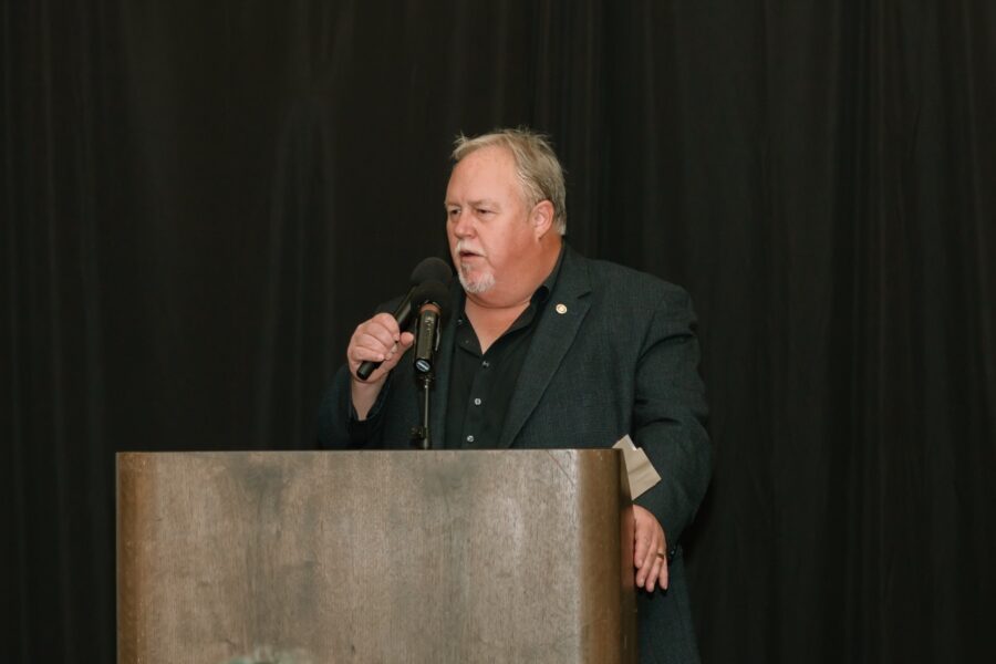 a man standing at a podium with a microphone