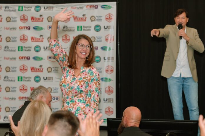 a woman standing on top of a stage holding a microphone