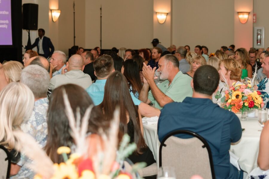 a large group of people sitting at tables in a room