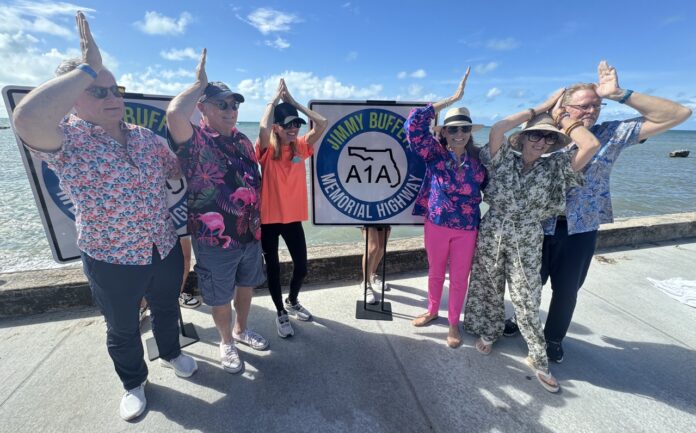 a group of people standing next to each other near the ocean