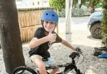 a young boy riding a bike on a dirt road