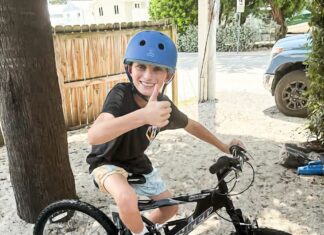 a young boy riding a bike on a dirt road