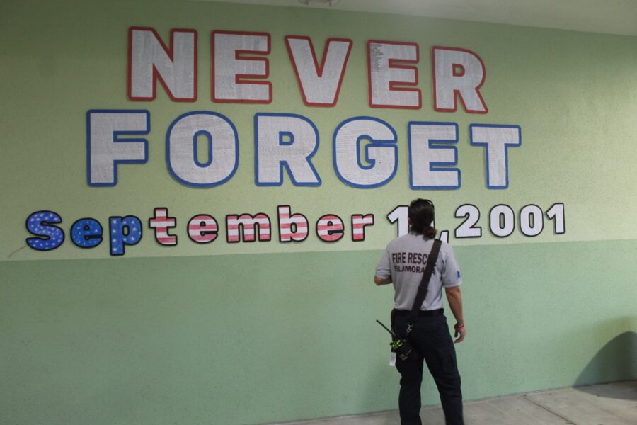 a woman standing in front of a sign that says never forget forget