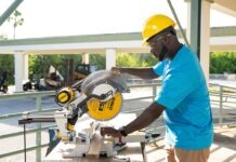 a man using a circular saw to cut a piece of wood