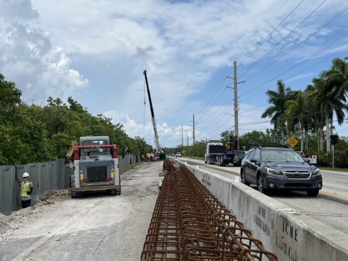 a street with a fence and cars on it