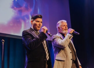 two men standing next to each other on a stage
