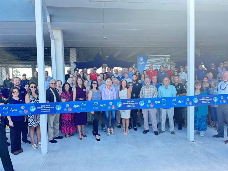 a group of people standing behind a blue ribbon