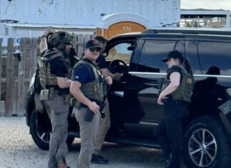 a group of men standing next to a black suv