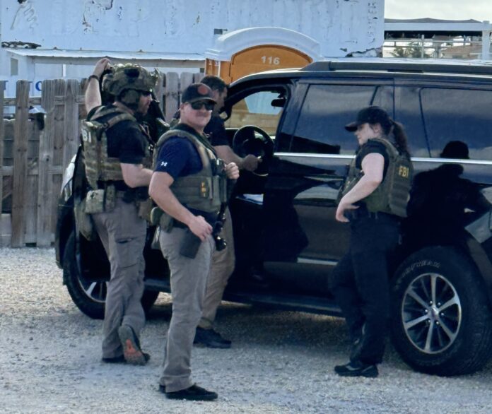 a group of men standing next to a black suv